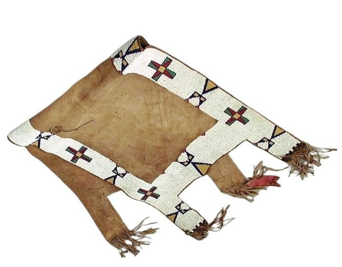 Traditional Native American saddle with fringes on a white background