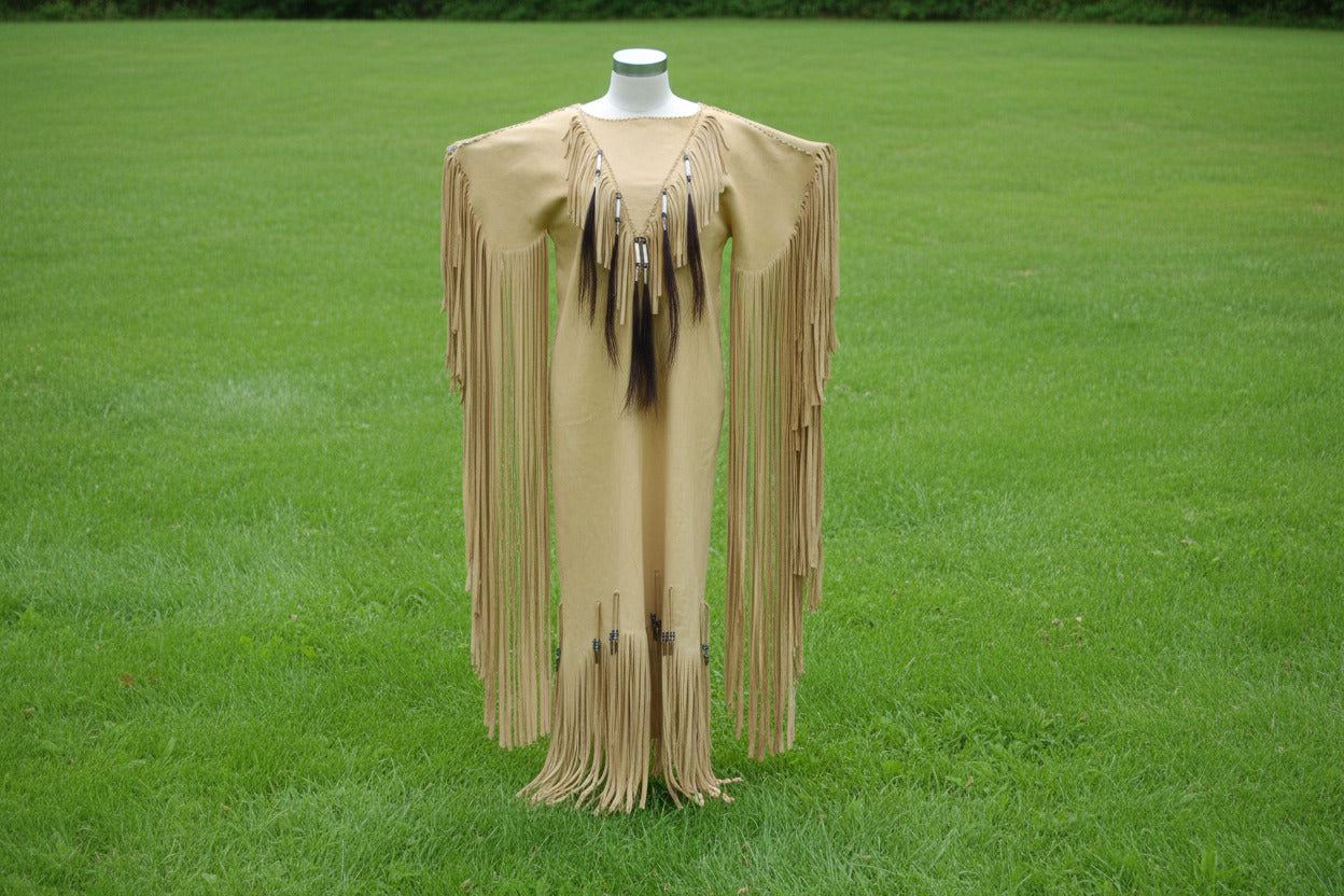 Beige fringe garment on a mannequin against a dark background