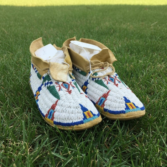 Pair of colorful Powwow beaded moccasins on grass