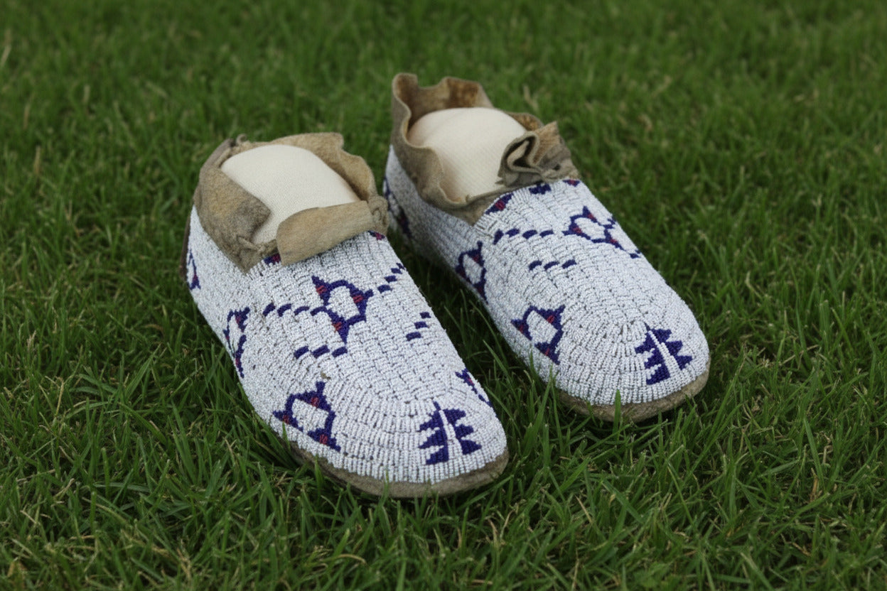 Pair of beaded moccasins on a white background