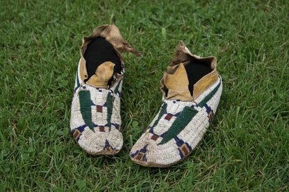 Pair of Native American beaded moccasins on a white background