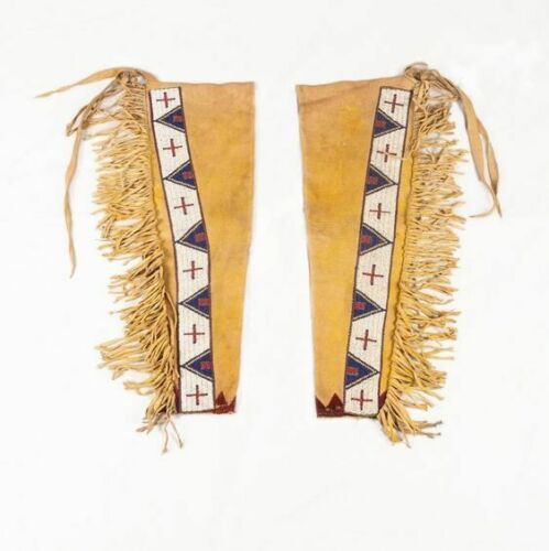 Two Native American-style leggings with fringes and patterned bands on a white background