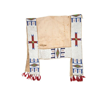 Decorative saddle blanket with geometric patterns and red fringes on a white background
