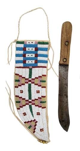 Beaded knife sheath and wooden knife on a white background