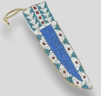 Decorative knife sheath with beadwork on a gray background