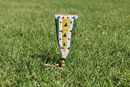 Decorative beaded knife sheath with corn design on a dark background
