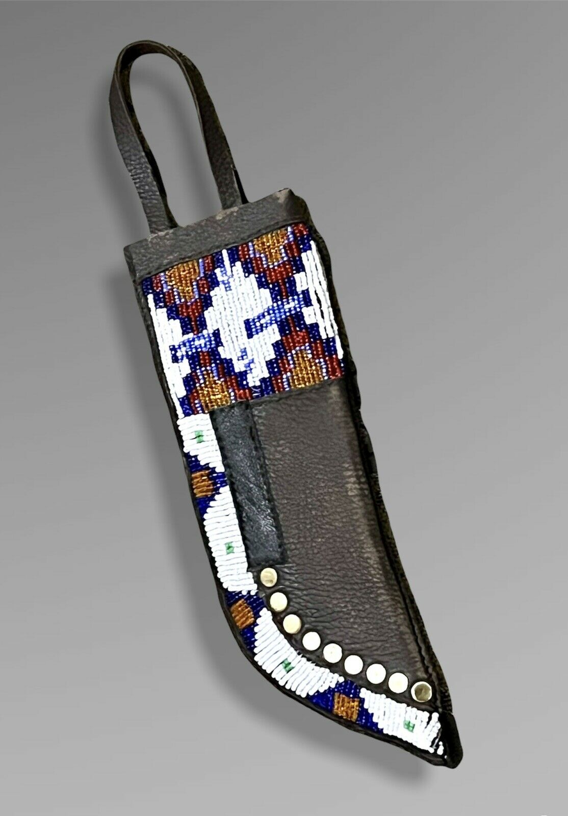 Decorative knife sheath with beadwork on a gray background