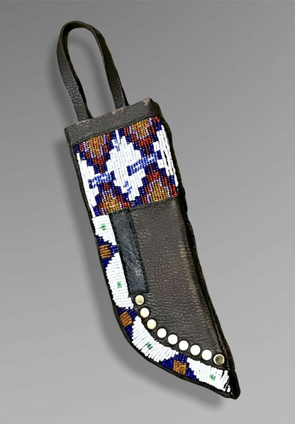 Decorative knife sheath with beadwork on a gray background