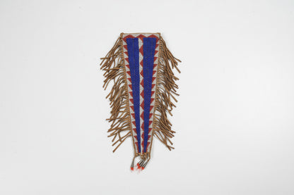 Decorative beaded knife sheath with fringes on a gray background