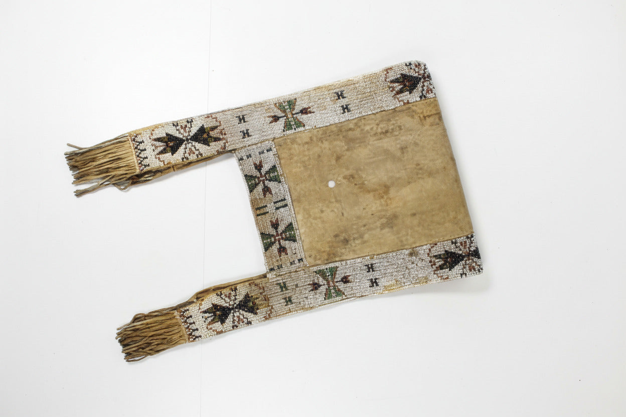 Decorative saddle blanket with geometric patterns and fringes on a plain background