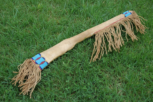 Traditional Native American rifle sheath with fringes on a white background