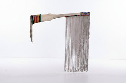 Traditional Native American rifle sheath with beads and feathers on a white background