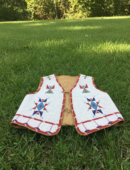 Traditional Native American vest with beadwork on grass
