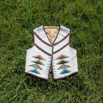 Traditional patterned powwow vest on grass