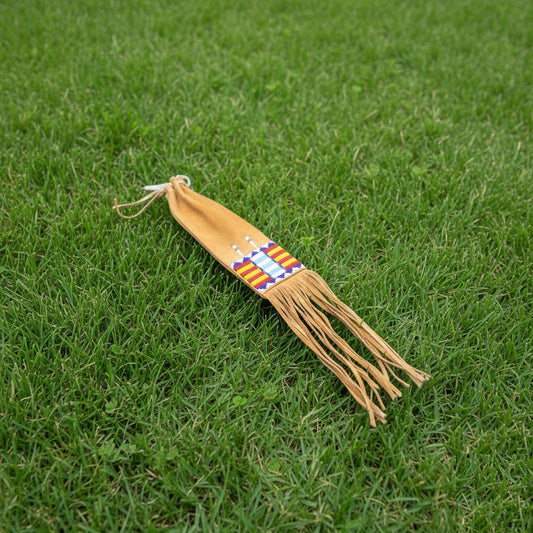 Decorative Pipe Bag with fringes and a colorful pattern on grass