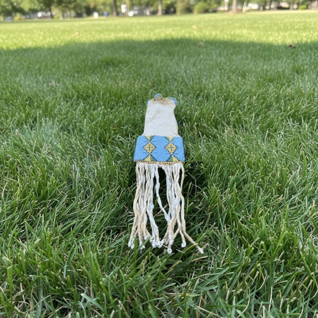 Decorative Pipe bag with blue top and white fringes on grass