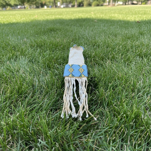 Decorative Pipe bag with blue top and white fringes on grass