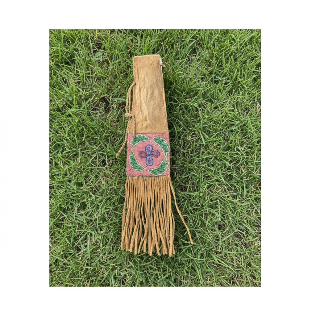 Decorative leather Pipe Bag with fringe and beadwork on grass