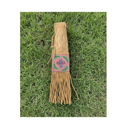 Decorative leather Pipe Bag with fringe and beadwork on grass