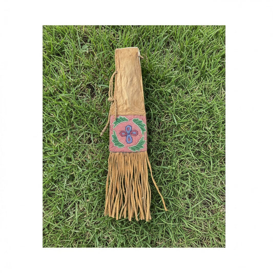 Decorative leather Pipe Bag with fringe and beadwork on grass