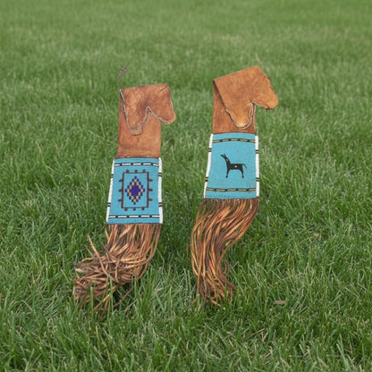 Two decorative horse pipe bag with patterned handles on a grassy background