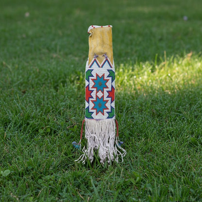 Decorative bag with geometric patterns and fringes on grass