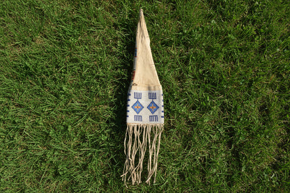 Decorative pipe bag with beads and fringes on a white background