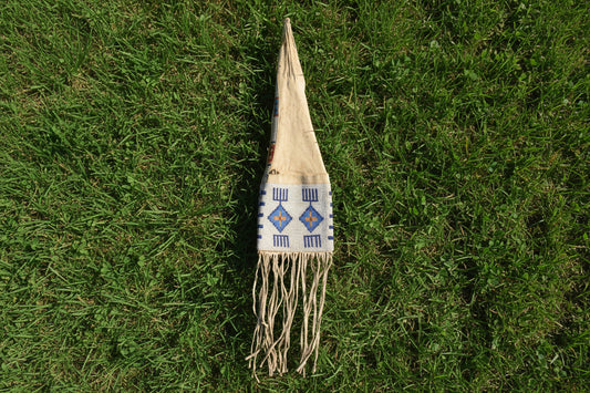 Decorative pipe bag with beads and fringes on a white background