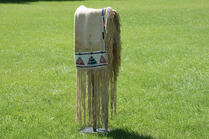 Native American-style saddle bag with fringes and beadwork on a white background