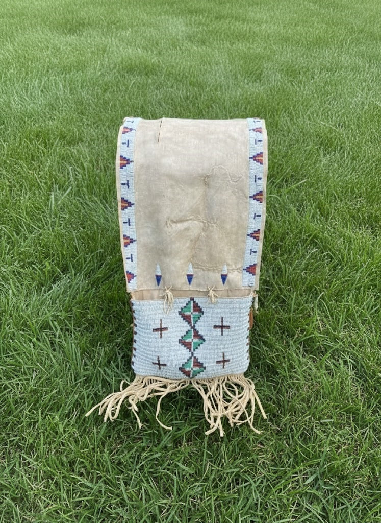 Traditional Native American saddle bag with geometric patterns on grass