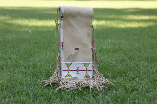 Beige leather saddle bag with fringe and beadwork on a white background