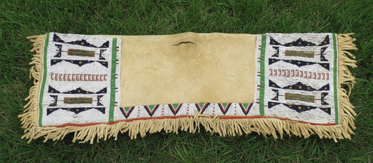 Native American-style saddle Bag with geometric patterns on grass