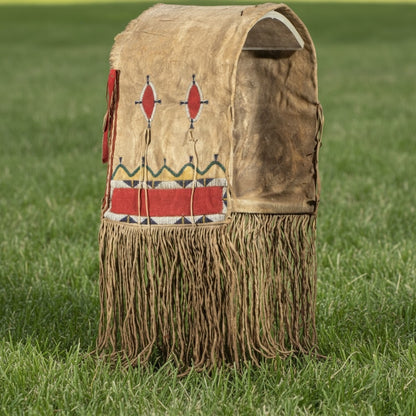 Traditional Native American style bag with fringes and geometric patterns on a grassy background