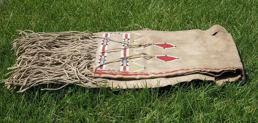Traditional Native American Bag with fringes on a grassy background