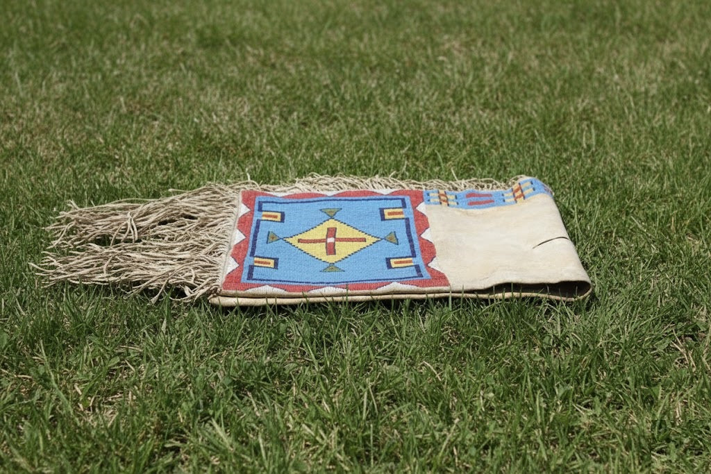 Traditional Native American Saddle bag with colorful design on grass