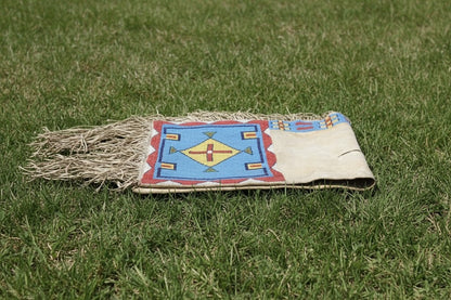 Traditional Native American Saddle bag with colorful design on grass