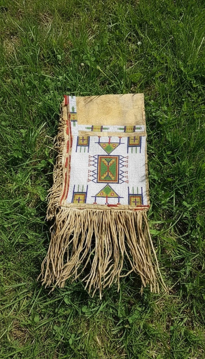 Handmade bag with geometric patterns and fringes on grass