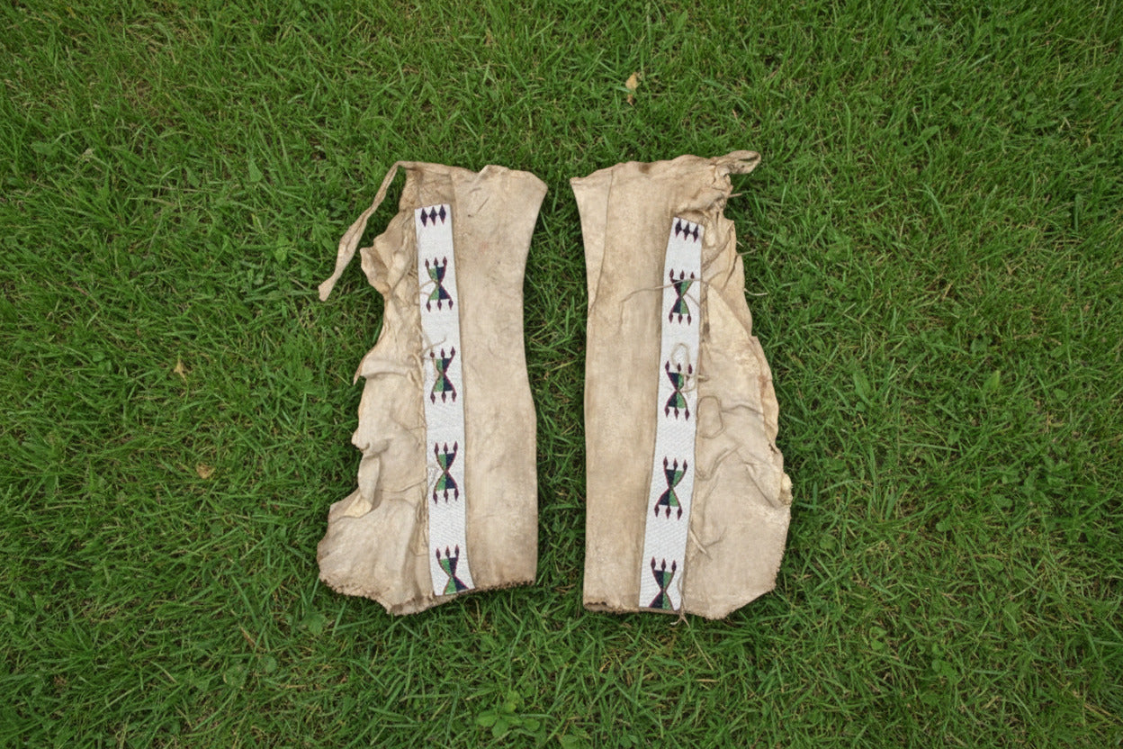Pair of traditional Native American leggings with decorative bands on a white background
