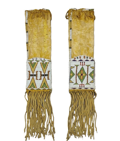 Pair of Native American-style pipe bags with intricate beadwork and fringes on a white background.