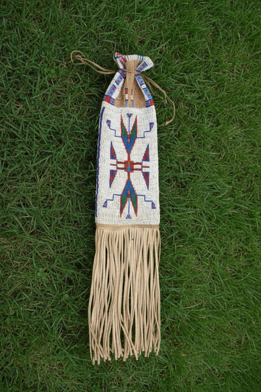 Decorative pipe bag with beaded design and fringes on a white background