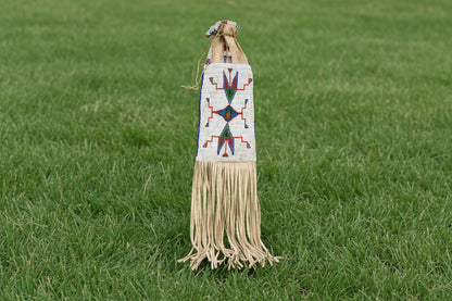Decorative bag with beadwork and fringes on a white background