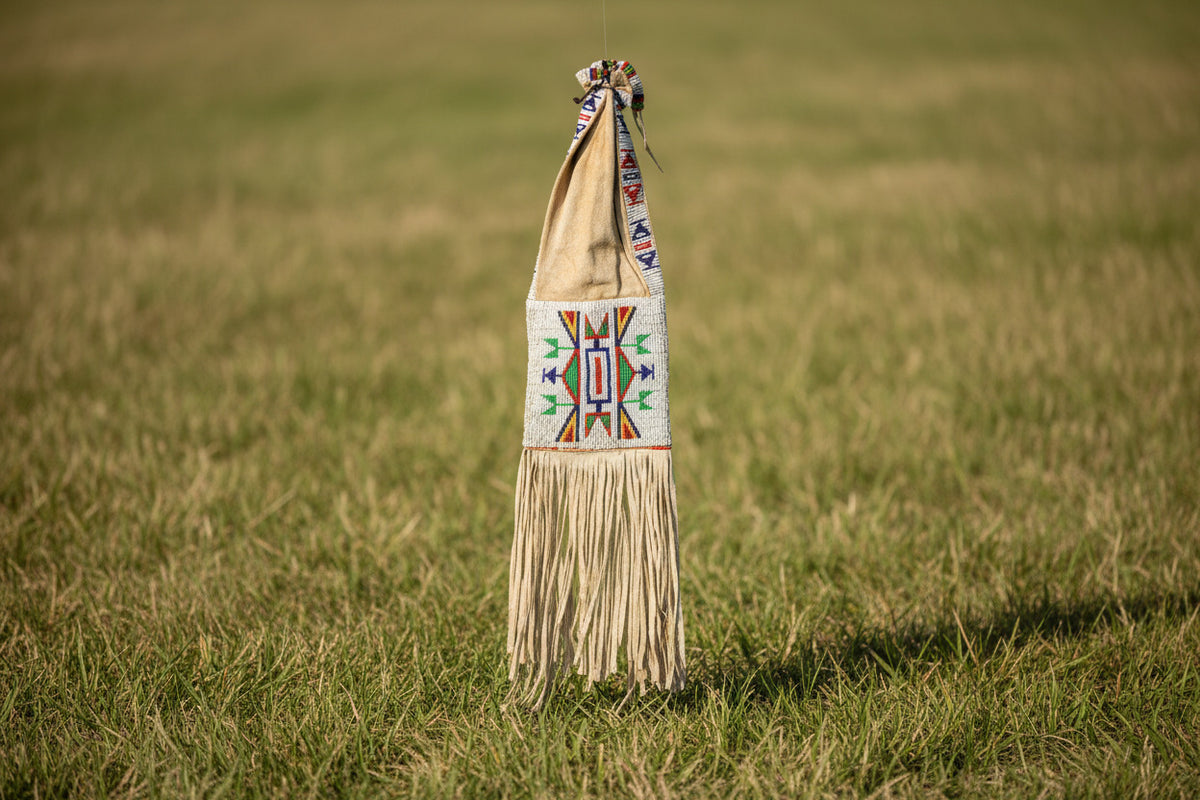 Traditional beaded bag with fringes on a white background