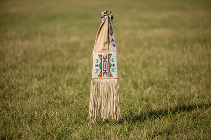 Traditional beaded bag with fringes on a white background